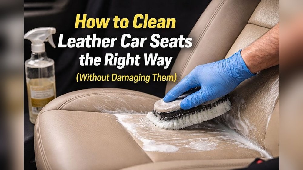 Person's hand applying leather cleaner to a beige leather car seat with a soft cloth.