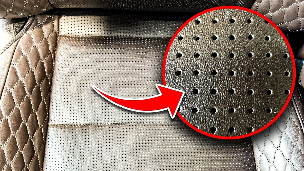 Close-up of perforated leather car seat surface showing small ventilation holes
