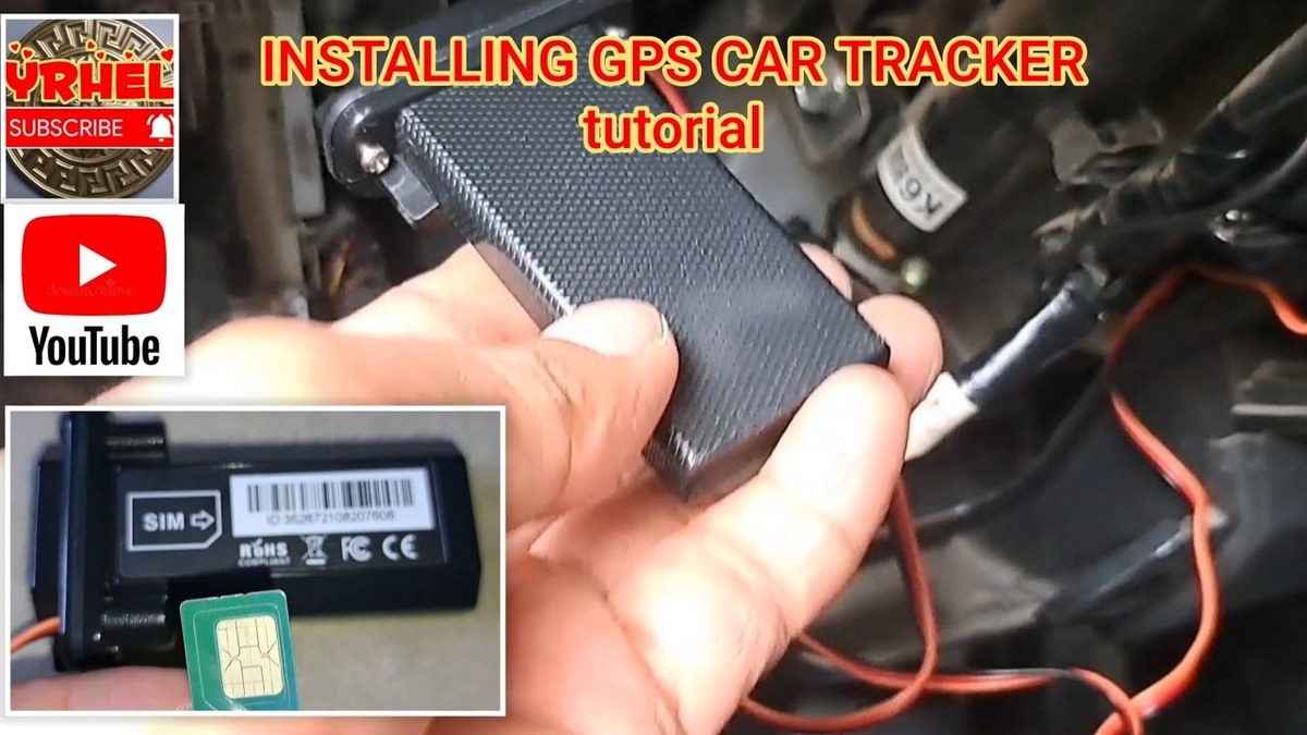 Close-up of hands installing a GPS tracker device under a car dashboard near steering column.